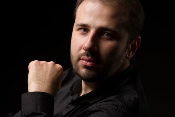 Portrait of Ukrainian pianist Stanislav Khristenko with a dark background